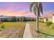 Charming community featuring a well-manicured lawn and tropical palm trees against a sunset sky at 6314 29Th W Ave, Bradenton, FL 34209