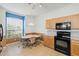 Bright eat-in kitchen features wood cabinets, black appliances, a ceiling fan and a lovely breakfast nook at 8995 Founders Cir, Palmetto, FL 34221