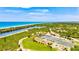 Gorgeous aerial view of the community amenities, including tennis and basketball courts, lush landscaping, and Gulf coast access at 1364 Berkshire Ct, Venice, FL 34292