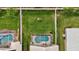 Aerial backyard view featuring screen-enclosed pool, green grass, and beautiful landscaping at 1364 Berkshire Ct, Venice, FL 34292