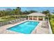Community pool with inviting lounge chairs, cabana, and well-manicured landscaping around it at 1364 Berkshire Ct, Venice, FL 34292
