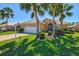 A well-maintained home featuring a pristine lawn, a two-car garage, and mature landscaping at 1364 Berkshire Ct, Venice, FL 34292