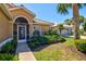 Inviting front entrance with screened porch and verdant landscaping, set in a quiet residential street at 1364 Berkshire Ct, Venice, FL 34292
