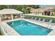 Community pool with adjacent cabana for shady relaxation, with ample lounge chairs by the crystal clear water at 1364 Berkshire Ct, Venice, FL 34292