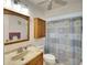 Cozy bathroom with a vanity, toilet and tub/shower combo enclosed by a patterned shower curtain and linen cabinet at 1430 57Th W St # 1430, Bradenton, FL 34209