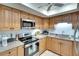 Well-lit kitchen featuring stainless steel appliances, granite countertops, and wooden cabinetry at 1430 57Th W St # 1430, Bradenton, FL 34209