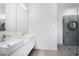 Modern bathroom featuring double vanity, sleek mirrors, and a frameless glass shower enclosure at 2254 Hawthorne St, Sarasota, FL 34239