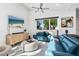 Open-concept living room with sleek furnishings, large windows, and beach view TV screen at 2254 Hawthorne St, Sarasota, FL 34239