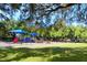 Community playground with colorful play structures, swings, and benches, all set within a fenced and grassy area at 2254 Hawthorne St, Sarasota, FL 34239