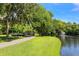Scenic view of a pond with a fountain, a walking path, a bridge, and lush green spaces at 2254 Hawthorne St, Sarasota, FL 34239