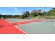 Well-maintained tennis courts with red and green surfaces, surrounded by fencing and lush greenery at 2254 Hawthorne St, Sarasota, FL 34239