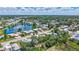 Scenic aerial shot showcases a tranquil neighborhood with homes situated around a peaceful pond, surrounded by lush trees at 2321 Terry Ln, Sarasota, FL 34231