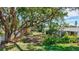 Lush backyard featuring mature trees, green grass, and well maintained landscaping at 2321 Terry Ln, Sarasota, FL 34231