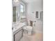 Well-lit bathroom featuring a white sink, toilet, and grab bars for accessibility at 2321 Terry Ln, Sarasota, FL 34231