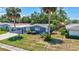 Charming single-story home featuring a carport, well-maintained lawn, and tropical landscaping with palm trees and shrubs at 2321 Terry Ln, Sarasota, FL 34231