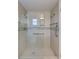 Modern shower with glass door, tiled walls, and grab bars for accessibility at 2321 Terry Ln, Sarasota, FL 34231