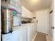 The laundry room has white cabinets and modern washer-dryer units at 2601 Gulf N Dr # 427, Bradenton Beach, FL 34217