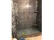 Walk-in shower features decorative tile accents, built-in shelving, and glass enclosure at 2950 Viscaya Pl # 205, Sarasota, FL 34237