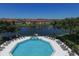 Community swimming pool with lounge chairs overlooking lake and buildings at 2950 Viscaya Pl # 205, Sarasota, FL 34237