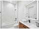 Modern bathroom featuring a tub and shower combo, wood vanity, and illuminated mirror at 3598 Trinity St, North Port, FL 34291