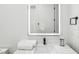 Bright bathroom featuring a large, illuminated mirror, white countertops, and modern fixtures at 3598 Trinity St, North Port, FL 34291