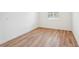 Bright, empty bedroom featuring wood-look flooring and a window with plantation shutters at 3598 Trinity St, North Port, FL 34291
