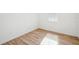 Bright, empty bedroom featuring wood-look flooring and a window with plantation shutters at 3598 Trinity St, North Port, FL 34291
