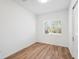 Bright bedroom featuring wood-look flooring and a large window with plantation shutters at 3598 Trinity St, North Port, FL 34291