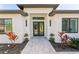 Elegant front entrance features black double doors, modern lighting, and manicured plants at 3598 Trinity St, North Port, FL 34291