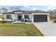 Attractive front exterior with a well-manicured lawn and dark two-car garage at 3598 Trinity St, North Port, FL 34291