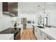 Bright kitchen with stainless steel appliances, white cabinetry, and hardwood floors at 3598 Trinity St, North Port, FL 34291