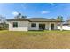 Rear exterior with covered patio featuring large sliding glass doors to the interior at 3598 Trinity St, North Port, FL 34291