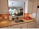 A well-lit kitchen features a sink with stone countertops, white cabinetry, and a view into the living room at 3720 El Poinier Ct # 515, Sarasota, FL 34232