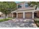 Townhome garages with neutral paint, white trim and brick driveways are shaded by mature trees at 4007 Overture Cir, Bradenton, FL 34209