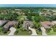 An aerial view of the tan-colored home with a golf course, lakes, and other homes nearby at 5304 96Th E St, Bradenton, FL 34211