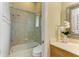 A bathroom includes a walk-in glass shower, toilet and vanity with decorative mirror and flower arrangement at 5304 96Th E St, Bradenton, FL 34211