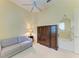 A well-lit bedroom featuring a gray sofa, a dark cabinet and a round mirror near the entry door at 5304 96Th E St, Bradenton, FL 34211