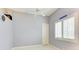 A bedroom with a ceiling fan, light-gray walls, a white door, and a window with plantation shutters at 5304 96Th E St, Bradenton, FL 34211