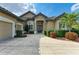 A beautiful tan-colored home with a three-car garage and a patterned driveway with lush landscaping at 5304 96Th E St, Bradenton, FL 34211
