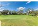 Expansive green golf course fairway with distant houses and pond under a bright blue cloudy sky at 5304 96Th E St, Bradenton, FL 34211