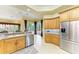Bright kitchen features wooden cabinets, stainless steel appliances, and view to the outdoor pool area at 5304 96Th E St, Bradenton, FL 34211