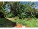 Lush backyard garden with various trees and plants, potted greenery, and space to enjoy the outdoors at 5808 13Th Street E Ct, Bradenton, FL 34203