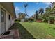 A backyard with green grass, tropical trees and flowers, and a storage shed at 5808 13Th Street E Ct, Bradenton, FL 34203