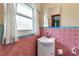 A bathroom featuring pink wall tiles with a white sink and toilet plus a window letting in natural light at 5808 13Th Street E Ct, Bradenton, FL 34203