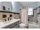 Tiled bathroom featuring a bath and shower with a black faucet and gray vanity with black hardware at 5808 13Th Street E Ct, Bradenton, FL 34203