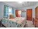 Charming bedroom with patterned curtains, a bed with decorative pillows, and an ensuite bath at 5808 13Th Street E Ct, Bradenton, FL 34203