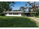 Charming single-story home featuring a well-maintained lawn, a carport, and a vibrant landscape at 5808 13Th Street E Ct, Bradenton, FL 34203