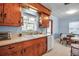 Charming kitchen with wooden cabinetry, a double basin sink, and view to the dining area at 5808 13Th Street E Ct, Bradenton, FL 34203