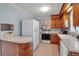 View of the kitchen showcasing wooden cabinets, a white refrigerator, and breakfast bar at 5808 13Th Street E Ct, Bradenton, FL 34203