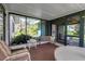 A sunroom with views of the yard, featuring a round table, chairs, a wooden bench, and several windows at 5808 13Th Street E Ct, Bradenton, FL 34203